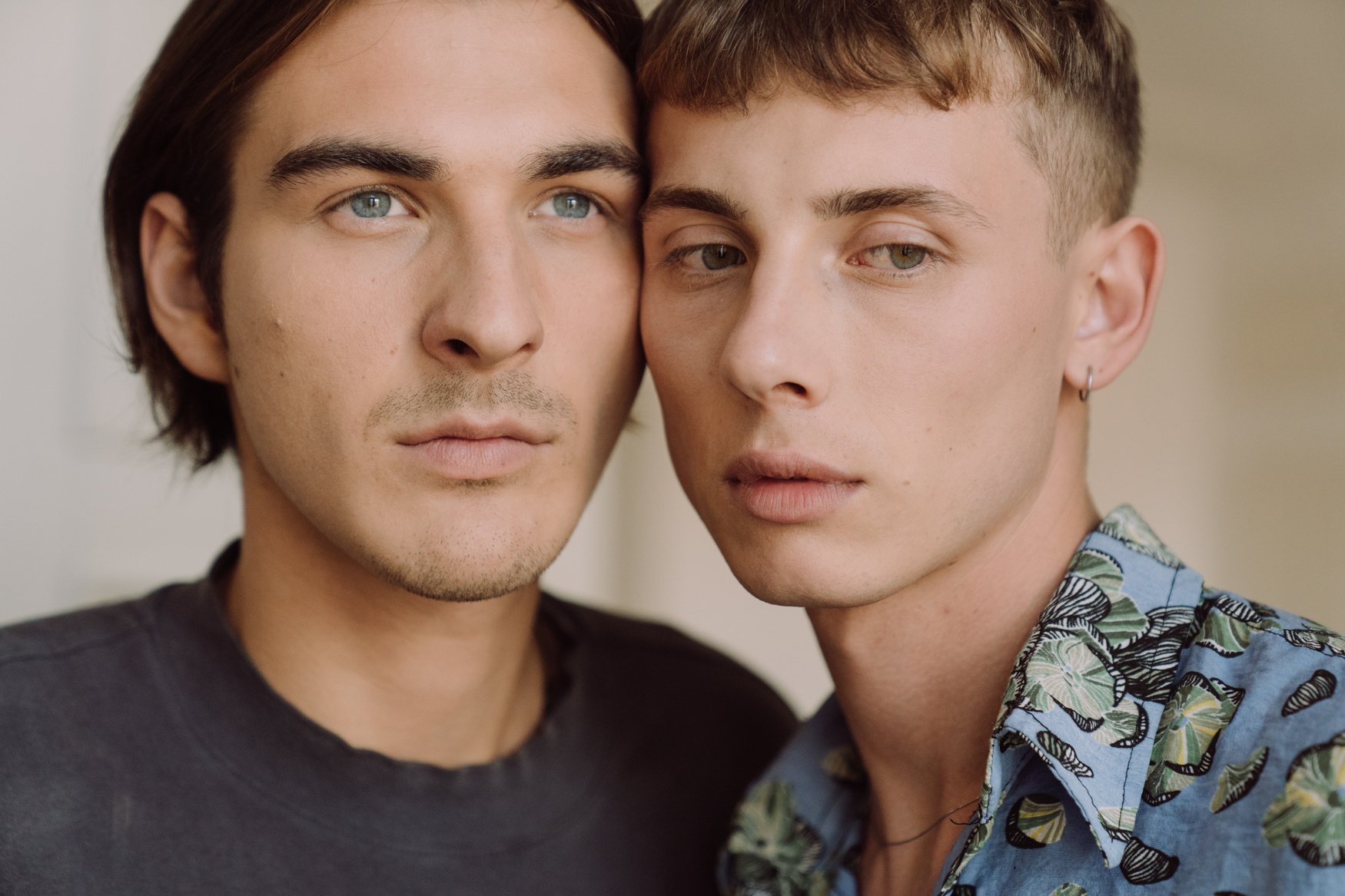 Man in Black Crew Neck Shirt Beside Man in White and Blue Floral Shirt